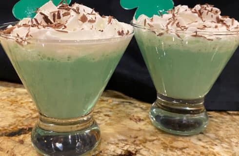 Green Martini with whipped cream topping and chocolate shavings in a clear martini glass