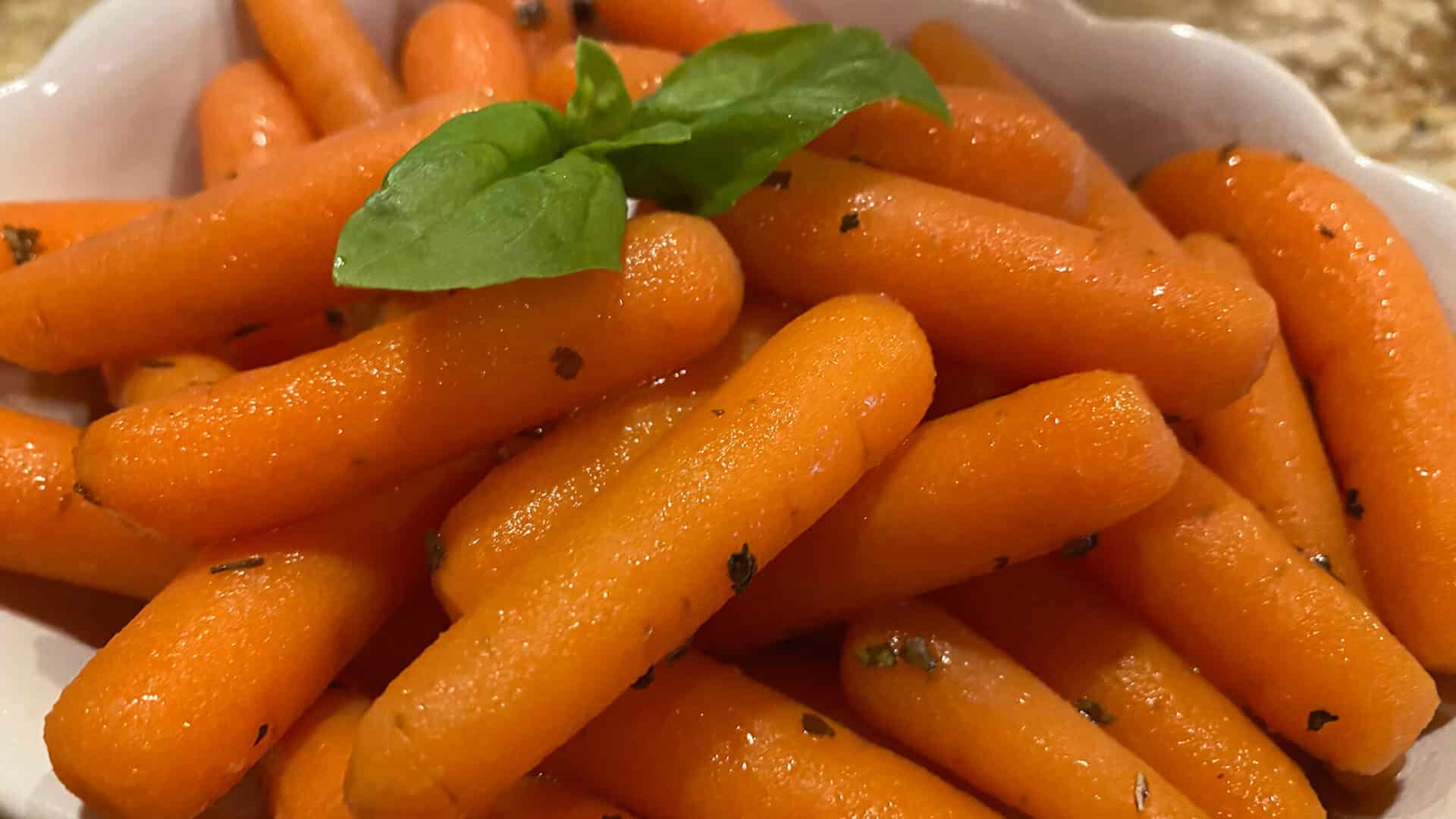 orange baby carrots with sprig of basil