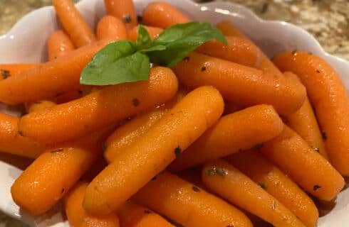 orange baby carrots with sprig of basil