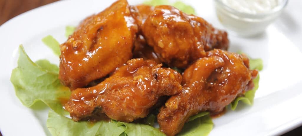 Buffalo Chicken Wings on a bed of lettuce with blue cheese dressing