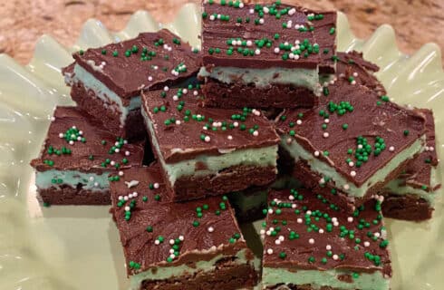 Chocolate brownies with a mint green frosting and chocolate ganache with green and white sprinkles