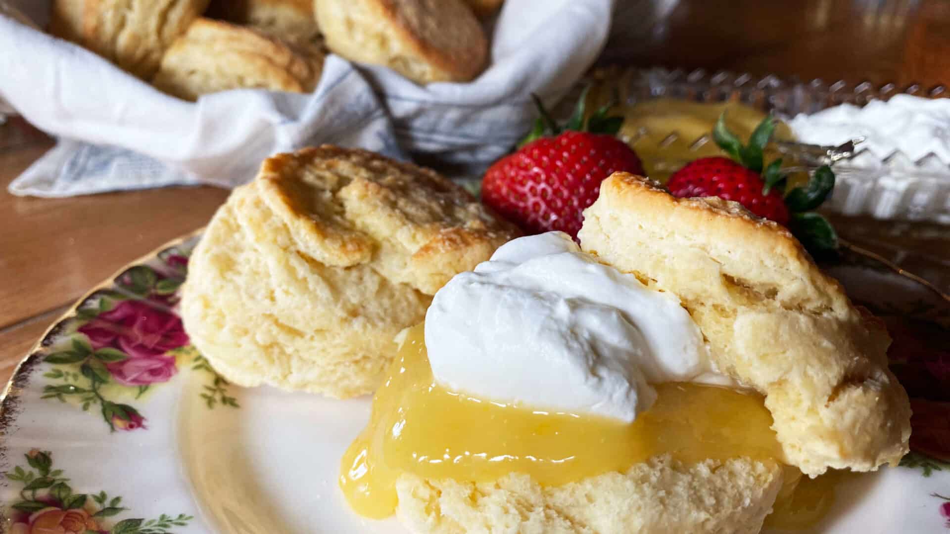 Flaky golden scones with lemon curdc devonshire cream, and fresh strawberries