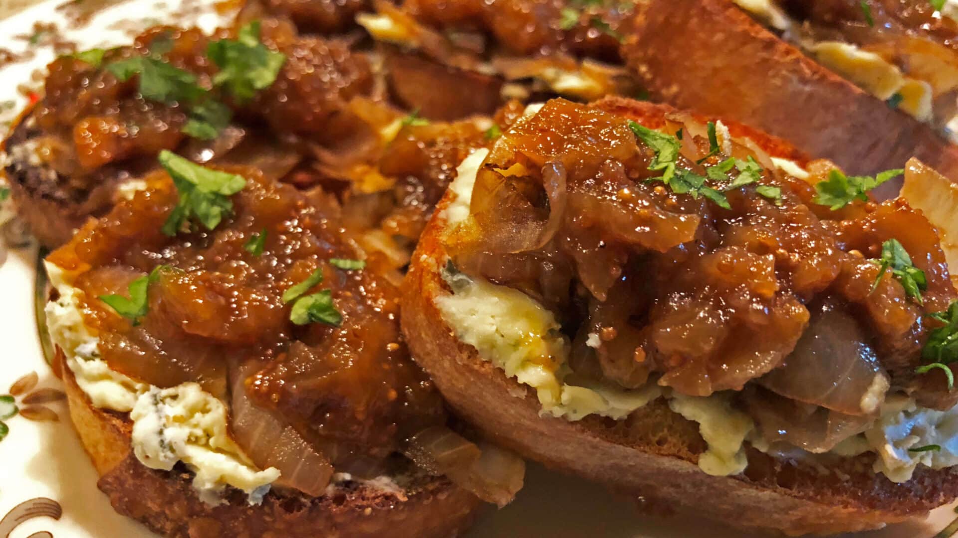 Toasted Crostini topped with melted white Gorgonzola cheese, golden caramelized onions, and sweet fig jam