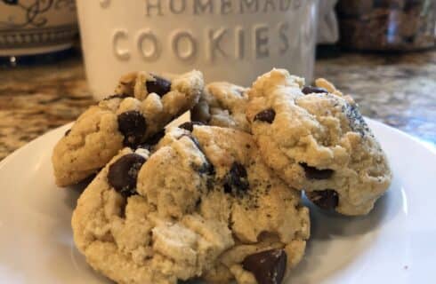 Buttery cookies with chocolate chips and a cookie jar in the background