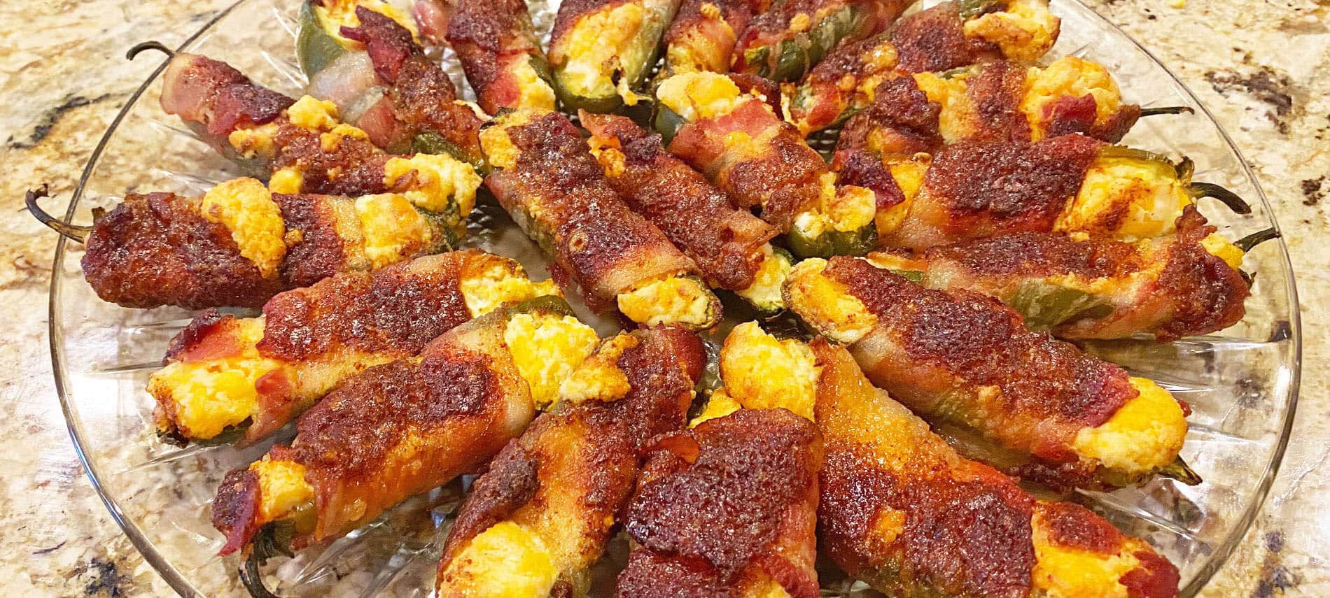 Bacon Wrapped Jalapeno Peppers filled with cheese and sprinkled with brown sugar and chili powder