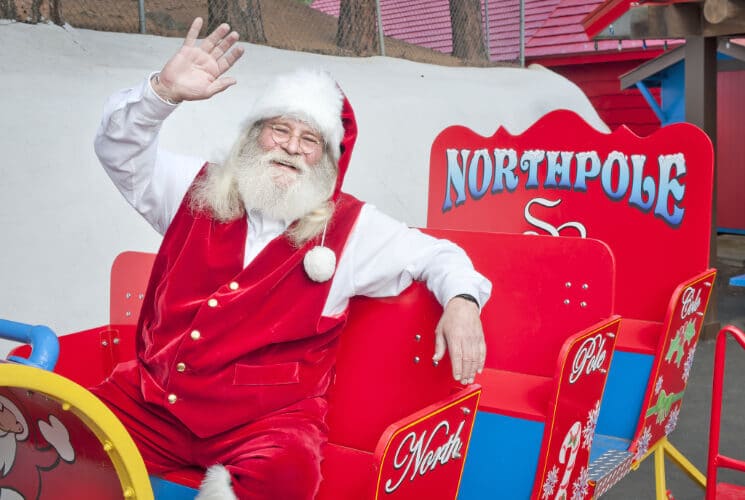 santa claus waving on his red sleigh that says NorthPole