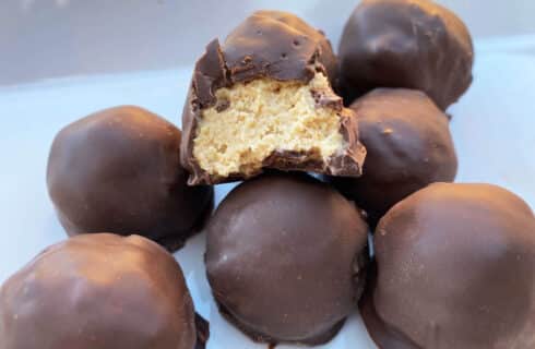 creamy peanut butter balls dipped in dark chocolate on a white plate