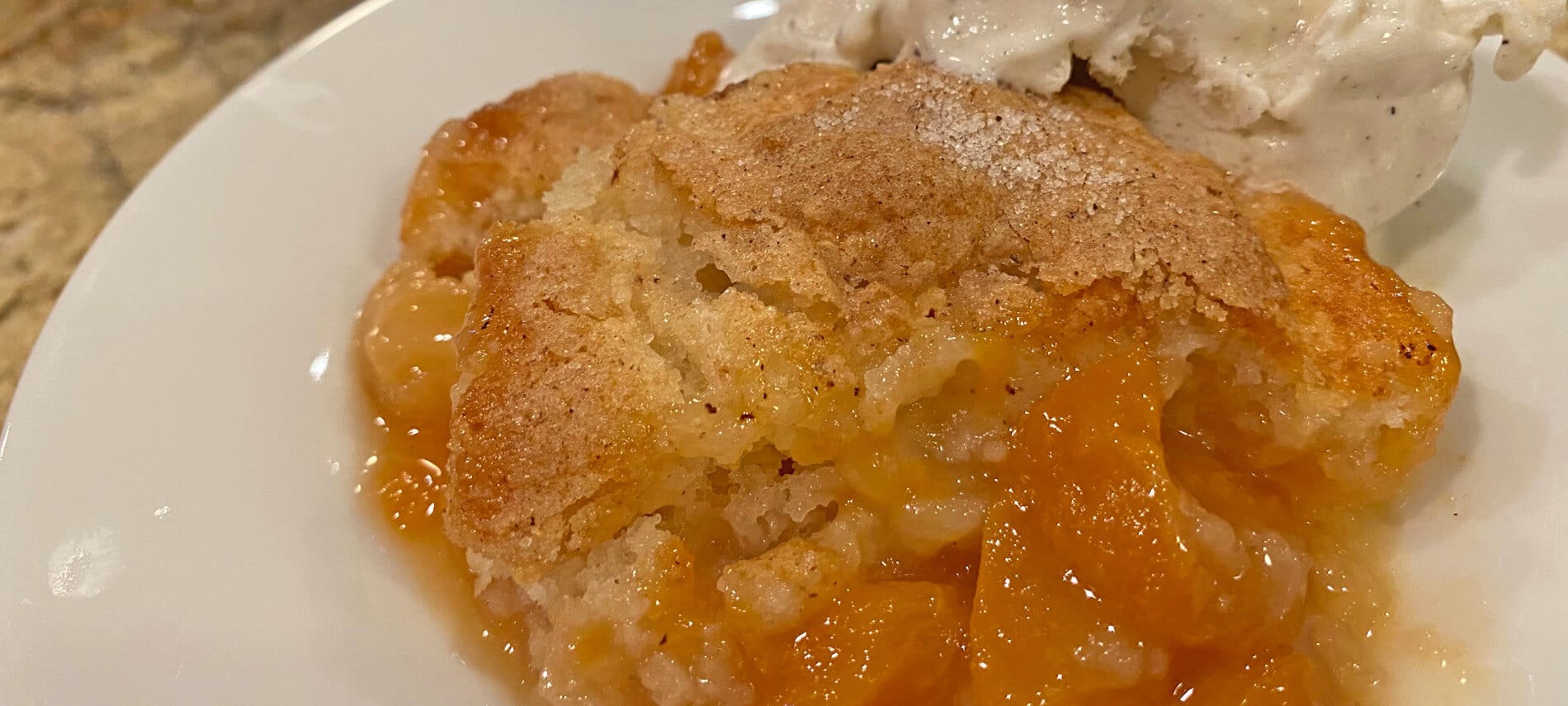 Juicy oranges peaches with a golden topping and white vanilla bean ice cream