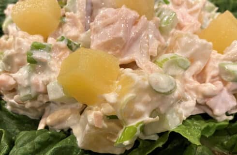 chicken salad with pineapple, green onions, celery, and toasted almonds in a creamy dressing on a bed of green lettuce