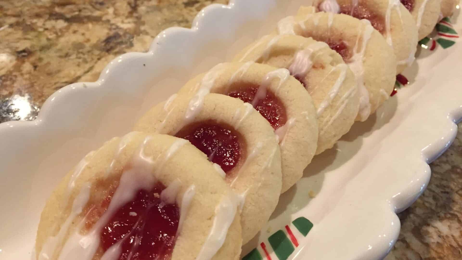 Buttery Shortbread Cookies with a filling of red raspberry jam and drizzled with white cing