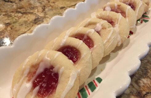 Buttery Shortbread Cookies with a filling of red raspberry jam and drizzled with white cing