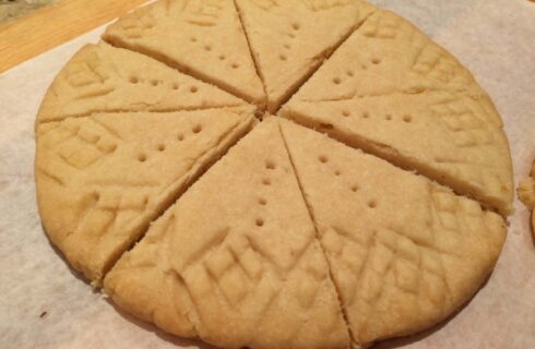 Round golden disc of buttery cookies cut into wedges with criss-cross edges