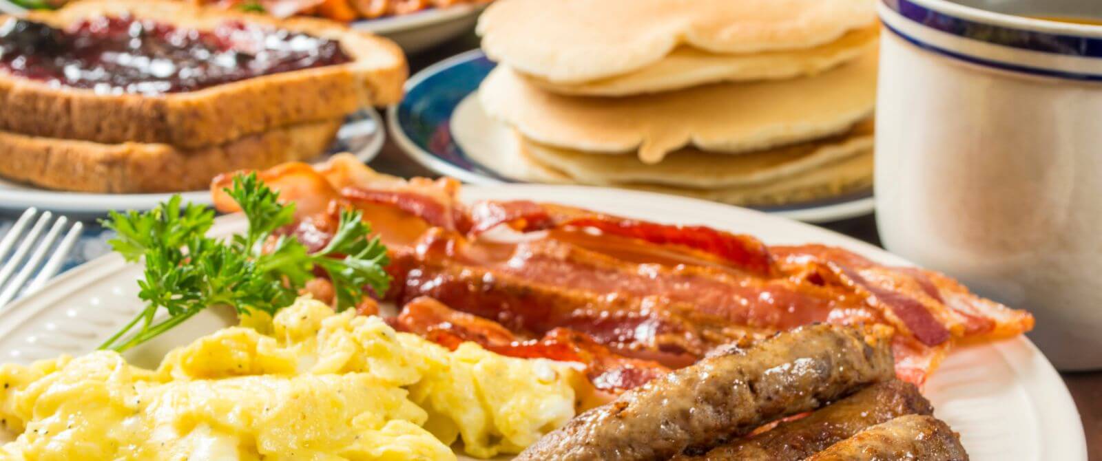 breakfast foods with eggs, bacon, pancakes and french toast