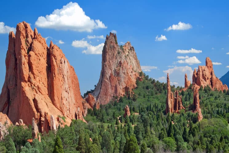 Beautiful red rock formations poking high above the pine trees with blue skies above