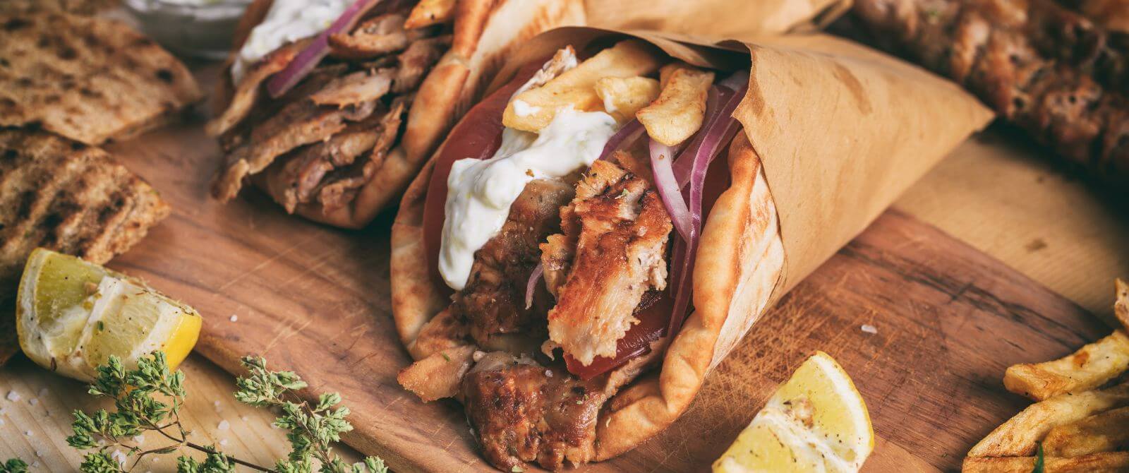 gyros willed with meat and drizzled with yogurt