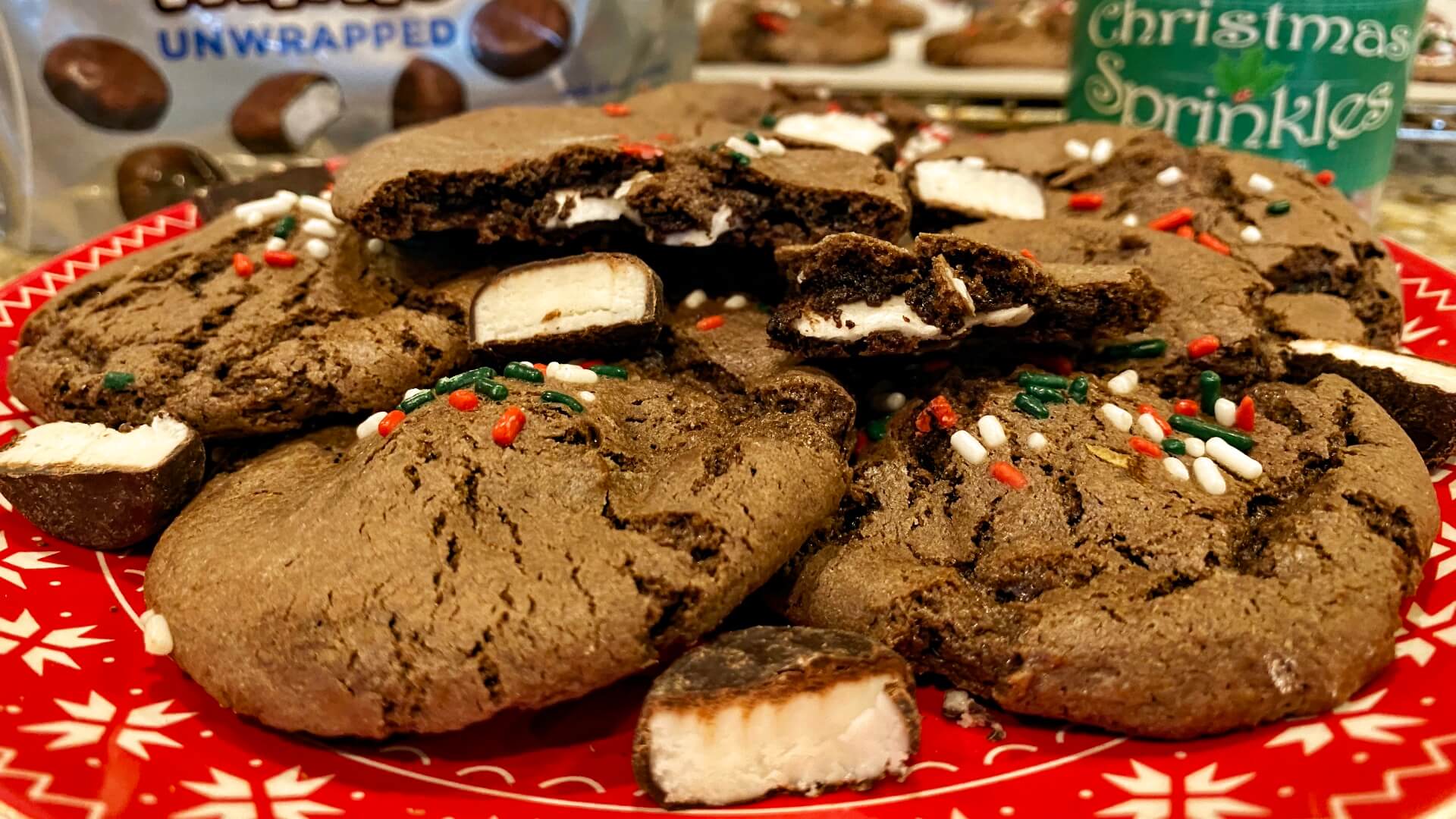 chocolate cookies filled with pieces of peppermint candy cookies and sprinkled with red, green and white sprinkles