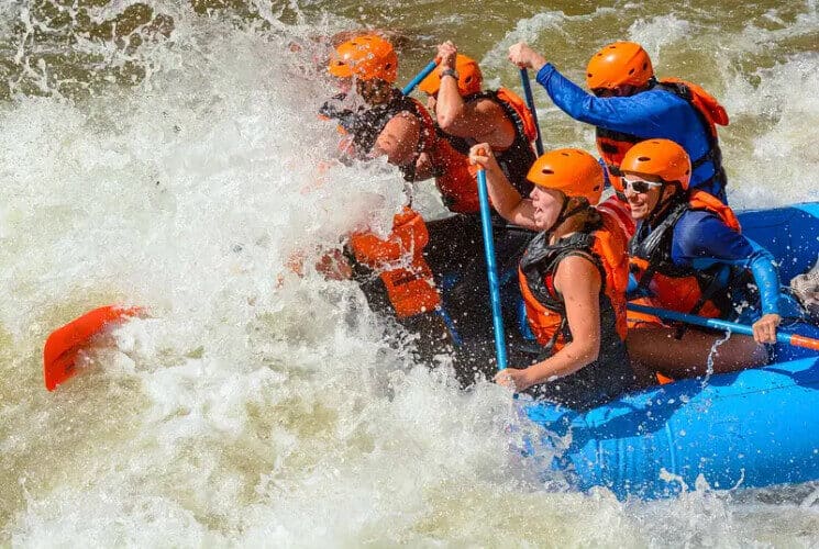 a group of people rafting through rough whitewater rapids