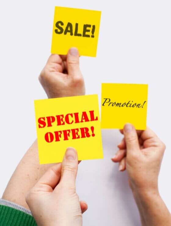 people holding up yellow signs that say special offers, sale, and promotion.