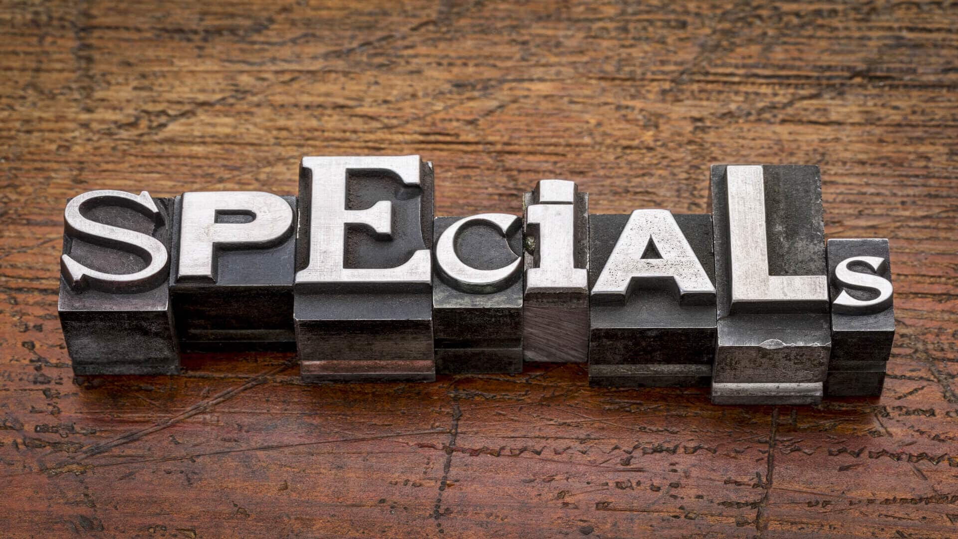 The word specials spelled out in blocks on a wood table