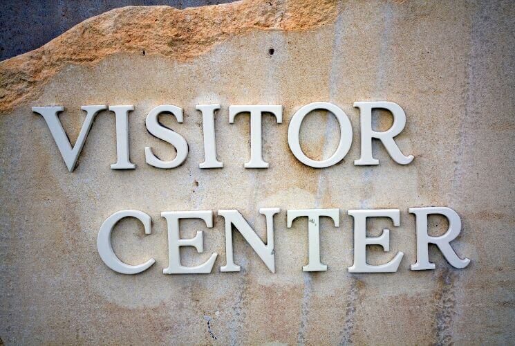 a stone sign with the words Visitor Center